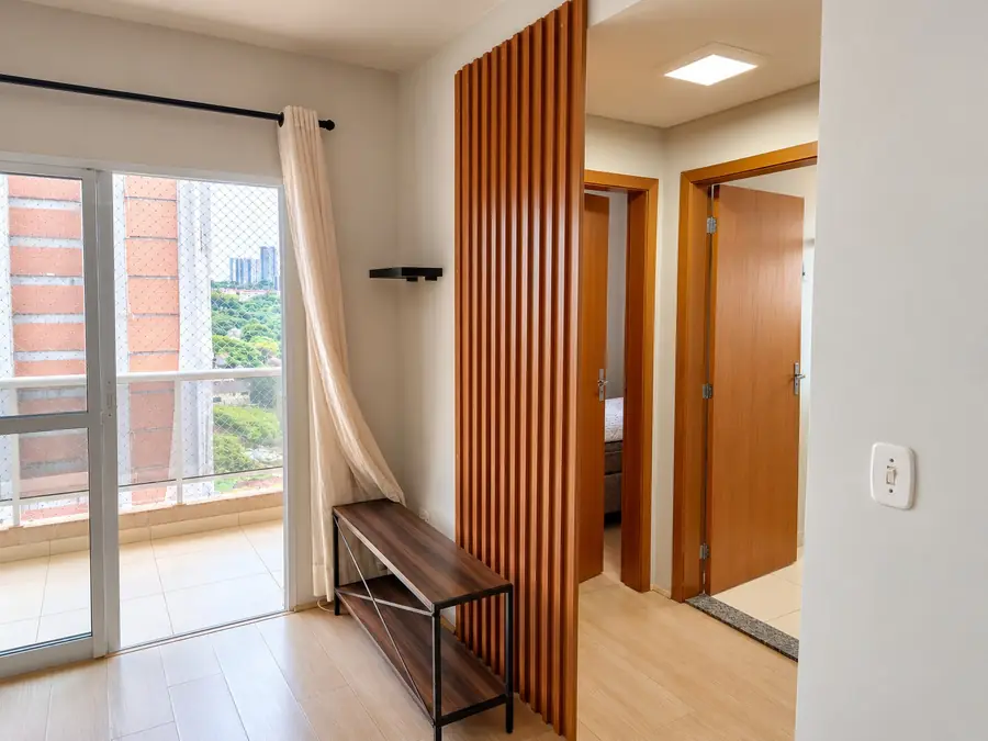 Sala com painel ripado e acesso aos dormitórios